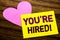 Hand writing text caption inspiration showing You Are Hired. Business concept for Hiring Employee Worker written on sticky note pa