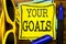 Hand writing text caption inspiration showing Your Golas. Business concept for Goal Achievement Written on sticky note paper, wood