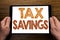 Hand writing text caption Tex Savings . Business concept for Tax Savings Extra Money Refund Written on tablet laptop, wooden backg