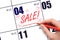 Hand writing text SALE and drawing gift boxes on calendar date May 4. Shopping Reminder