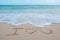 The hand writing word I love you on the beach by the sea with white waves and blue sky