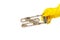 A hand in a yellow glove holds the heating element of a washing machine or dishwasher, covered with a lime coating. The