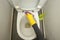 Hand in yellow gloves toilet wash