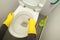 Hand in yellow gloves toilet wash