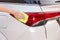 Hand with yellow microfiber cloth cleaning big white taillight c