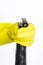 Hand in yellow rubber glove holding black plastic spray detergent bottle. Household chemicals. Cleaning product