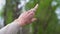 Hand of young girl in a beige blouse shows with her index finger with magic ring in the sky, forward, point the road