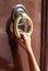 hand of young girl knocks on the door with the big brass handle