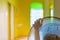 Hand of Young man touch and adjust  on front grills of electric fan for a good wind in his home in summer