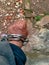 The hand of young man is wearing the iron linking chain bracelet with soil surface texture occurs in the outdoor