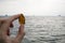 Hand of a young person holding a piece of brown sea washed glass.