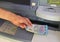 Hand of young person withdrawing Euro 20 banknotes in a bank ATM