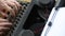 Hand of a young woman writer writing on antique typewriter