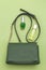 Handbag green color and disinfection gel on green background.  Monochrome. Vertical format