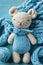 Handcrafted blue knitted toy, ideal for baby boy announcements, crafting blogs, toy store promotions, and cozy childhood
