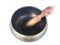 Handcrafted brass singing bowl with wooden stick put on the floor. Isolate background