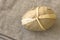 Handcrafted Easter egg wrapped in brown craft paper on linen cloth, top view