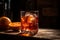 A handcrafted negroni drink, complete with ice and an orange slice, sitting on a wooden table, in a vertical closeup. Generative A