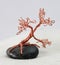 Handcrafted and painted wire tree attached to rock