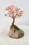 Handcrafted and painted wire tree for fall  attached to rock