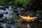 handcrafted paper boat with a candle inside set ablaze on a creek