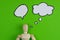 Handcrafted wooden man figure mannequin model dummy doll with blank speech bubble on green background, objects, nobody