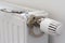 Handcuffs hanging on radiator near white wall indoors