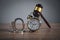 Handcuffs, judge gavel and alarm clock on the wooden background
