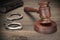 Handcuffs, Judge Gavel And Old Law Books On Wooden Table