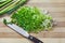 Handful of chopped green onions on striped wooden board