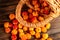 Handful of cloudberry berries poured from a small basket on an old wooden board close-up