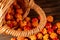 Handful of cloudberry berries poured from a small basket on an old wooden board close-up