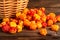 Handful of cloudberry berries poured from a small basket on an old wooden board close-up