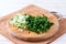 Handful of finely chopped green onions and dill on wooden board