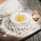 Handful of flour with egg yolks close up