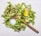 Handful fresh salad Lollo rosso with a wooden spoon, oil and salt wooden rustic background top view close up
