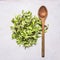 Handful fresh salad Lollo rosso with a wooden spoon, wooden rustic background top view close up
