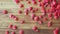 Handful of red ruspberries throwing on table, close shot. Texture of wooden table. Handful of fresh ripe raspberries