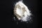Handful of sieved flour with heart shape hole in the center on black table, St Valentine`s concept, Love relations, cosy home,