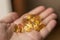 A handful of vitamin d capsules is in a man`s hand.