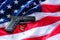 A handgun and bullets on American flag background.