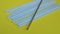 Handheld closeup shot of lots of plastic drinking straws on a colourfull yellow background - a hand of a person put one