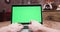 Handheld dynamic POV shot of computer display with green screen