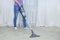 Handheld gray vacuum cleaner in the hand of  caucasian woman. Vacuum the floor in the room