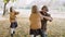 Handheld view of family playing with autumnal leaves