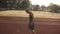 Handhelded footage of young athlete male stretching his hands on a track in stadium, preparing for running or training