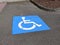 Handicap icon at a parking spot in a paved lot outdoors
