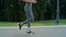 Handicapped female jogger running on asphalt road. Girl training outdoors