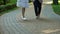 Handicapped little child going for walk with elder nurse near medical clinic