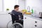 Handicapped Man Cleaning Dishes In Kitchen